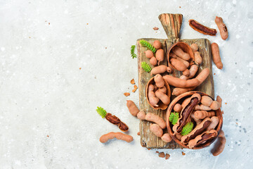 ripe tamarind on a kitchen wooden board. On a stone background. Top view.