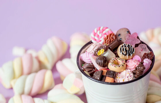 Marshmallows. Chewing candy close-up on a pink background. Dessert of sweet dishes in a white bucket. Pastel colors. A copy of the text space.