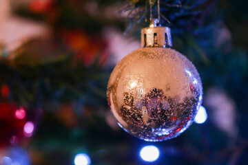 Primo piano di una boccia argento appesa all'albero di natale, festività e decorazioni natalizie