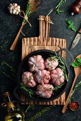 Turkey cutlets wrapped in turkey fillet, ready to cook. Barbecue. On a black concrete background. Top view.