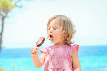 A Happy child girl with ice cream by the sea in nature in the park journey