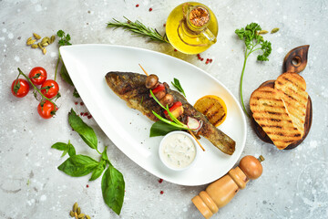 Baked river trout fish with vegetables on a plate. Seafood. Top view. Free space for text.