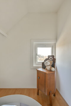 Toy on wooden cabinet in furnished baby room