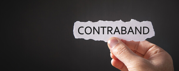 Man showing Contraband word on paper.