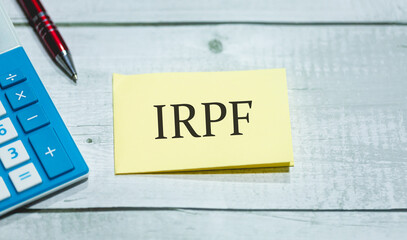 A sigla IRPF de Imposto de Renda da Pessoa Física em Português do Brasil escrita em um pedaço de...