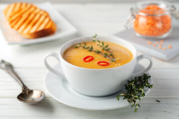Red lentil soup puree on a wooden table. View from above.