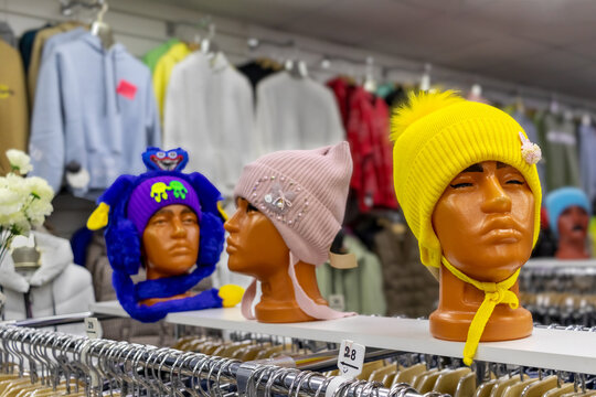 Mannequins of women's heads in funny hats in a cheap store. Tastelessness, addiction to shopping. Women's Day