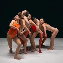 Experimental dance. Group of young beautiful flexible girls in bodysuits performing, dancing...