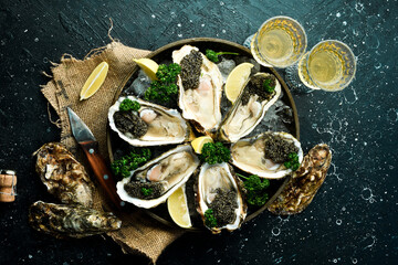 Oysters, caviar and wine, on ice. On a stone background. Top view. Delicacy