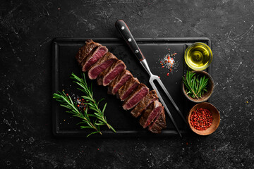 Beef Sirloin steak. Juicy cooked steak with rosemary and spices. Top view. Rustic style. Flat Lay.