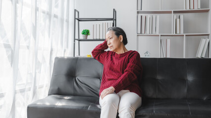Elderly asian housewife woman sitting on sofa. depression