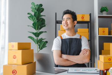 Young asian sme business man in apron working at warehouse home office freelancer retail logistic company with package box checking customer address.