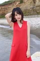 屏風ヶ浦にてポーズをとる赤いワンピースを着た若い女性	