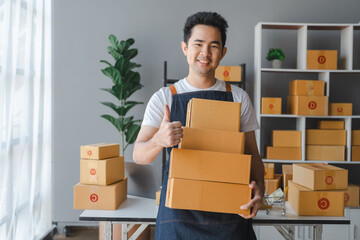 Young asian sme business man in apron working at warehouse home office freelancer retail logistic company with package box checking customer address.