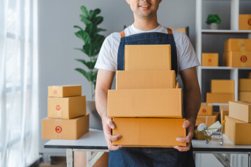 Young asian sme business man in apron working at warehouse home office freelancer retail logistic company with package box checking customer address.