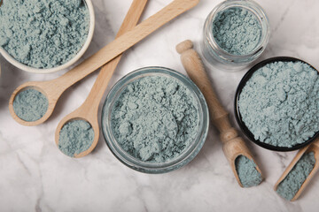 Obraz na płótnie Canvas Blue spirulina powder in jars, bowls and spoons on a marble background. Natural superfood, vegan, healthy food supplement. Phycocyanin extract. Antioxidant. Place for text. Copy space.