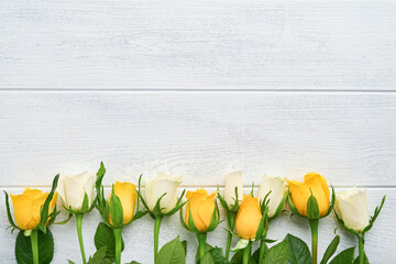 Happy Easter. Yellow and white roses on white wooden background. Easter background with copy space. Floral pattern. Greeting card. Mock up. Space for text.