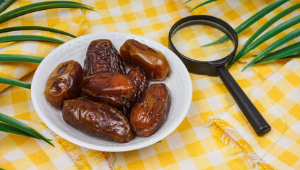 Pile of sweet dried dates in white plate. Popular product for boosting immunity. selective focus