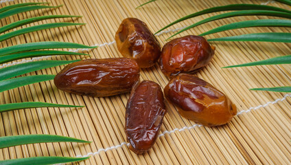 Dried date palm fruits or kurma over bamboo background. Traditional, delicious and healthy ramadan