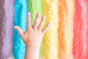 one hand in rainbow textured background 