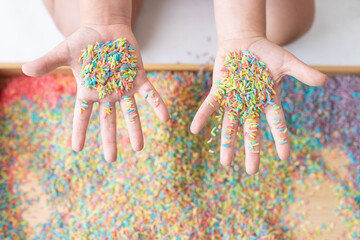Two hands in sensory bin palms up