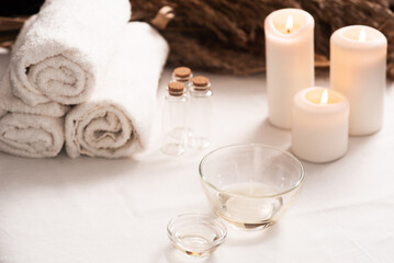 Spa still life with aromatic candles,oils and towel. Dark background