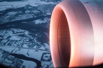 White airplane turbine close-up on a background of a snow-covered landscape. View of the ground,...