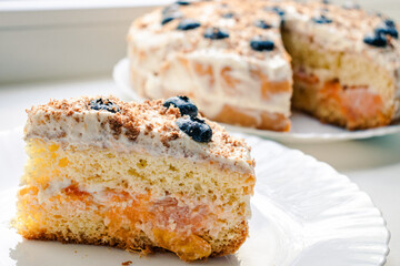 Cream sponge cake on a plate with berries, blueberry