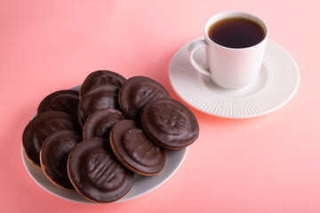photo lots of cookies in a plate next to a cup of coffee next to