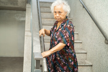 Asian senior or elderly old lady woman patient use slope walkway handle security with help support...