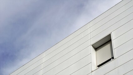 window with shutter on modern building facade against the sky