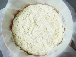 Fresh ricotta cheese in a white sieve close up , cottage cheese in a sieve ,soft ricotta cheese, process of making cottage cheese, process of making homemade cheese in a workshop, cheese for package d