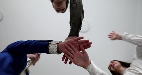 Together successful business people put hands together in office closeup