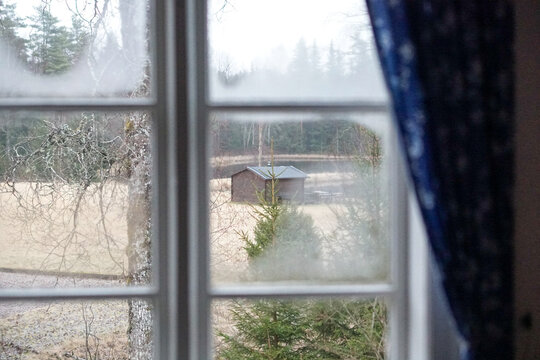 Houses and Barns in foggy weather at the end of Winter in the countryside area of Sweden, view from the insude
