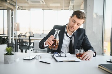 Businessman drinking from stress at workplace