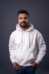 man with dark hair, mustache beard in gray (grey) background wearing white hoodie empty print copy space. Man looking at camera and smiling. White casual sports clothes 