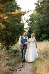 the groom and the bride are walking in the forest