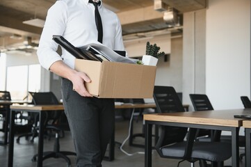 Economist leaving office. Handsome economist leaving the office taking his box with different things