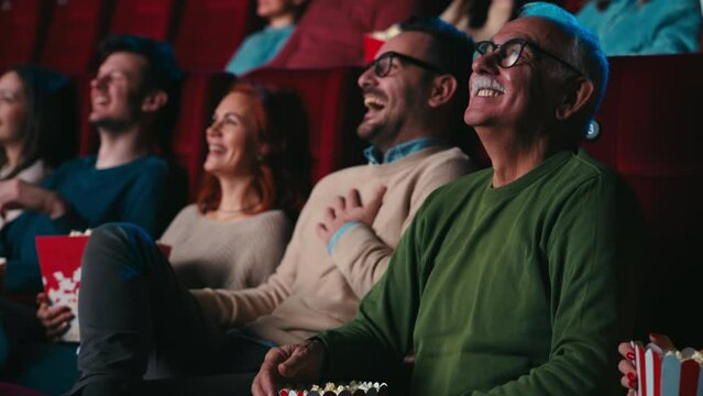Joyful senior watching movie in cinema.