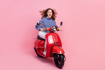 Full body photo of overjoyed positive lady drive moped have good mood isolated on pink color...