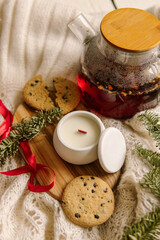 Wax candle in white concrete cup with lid. Cozy winter evening. Natural. Tea, candle and cookies