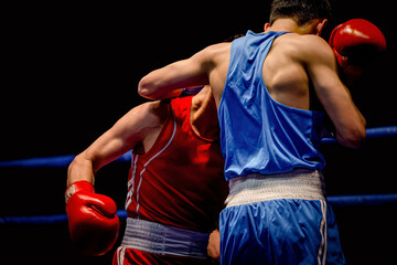 boxing match two boxers in ring on black background