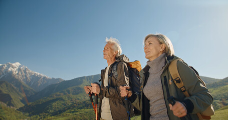 Mature caucasian couple on vacation, having a hike in spring mountains, spending time together...