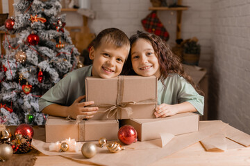 boy and a girl are sorting Christmas gifts packed in craft paper