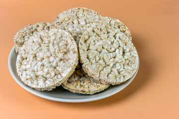 Wheat crumbs on a plate on an orange background