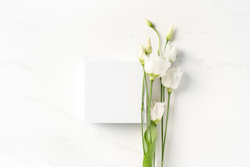 Summer minimal scene for beauty cosmetic product presentation made with white cube and Lysianthus flower on white background.