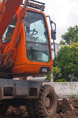 Orange hydraulic excavator at a construction site