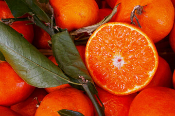 Stack of clementines with one cut in half on a market stall