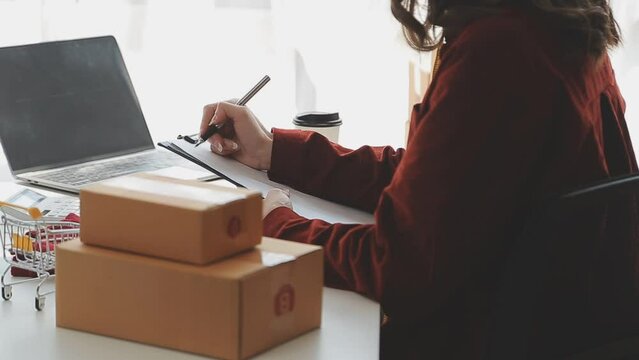 Fashion designer l young asian woman working using laptop, tablet and smiling while standing in workshop Responding on business