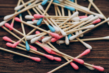 Eco cosmetic cotton buds on a wooden base, natural cotton in pink and blue color.
